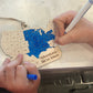 Person coloring a wooden map of the United States with markers