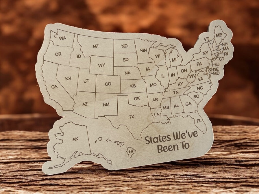 Wooden cutout of the United States with 'States We've Been To' text on a wooden surface